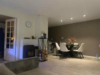 a living room with a table and white chairs at Feriebolig sentralt og nærme Ski VM in Tiller