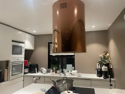 a kitchen with a large copper hood over a counter at Feriebolig sentralt og nærme Ski VM in Tiller
