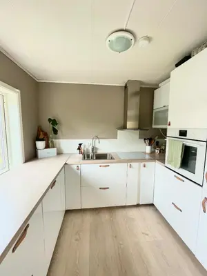 a white kitchen with white cabinets and a sink at Cozy and spacious apartment in Trondheim