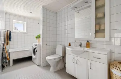 a white bathroom with a toilet and a sink at Cozy and spacious apartment in Trondheim