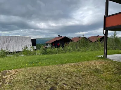 an open field with a barn in the distance at Spacious Retreat With Sauna And Parking in Beitostøl