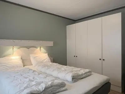 a bedroom with a large bed with white sheets at Spacious Retreat With Sauna And Parking in Beitostøl