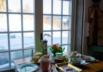 a table with food on it in front of a window at Cozy Cabin Retreat in Scenic Valley, E6 south of Trondheim in Storen