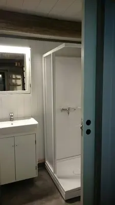 a bathroom with a shower and a sink and a door at Cozy Cabin Retreat in Scenic Valley, E6 south of Trondheim in Storen