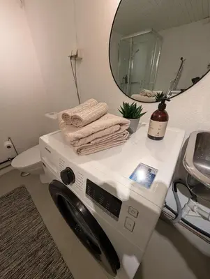 a washing machine in a bathroom with a mirror at Koselig kjellerleilighet, gratis parkering! in Trondheim
