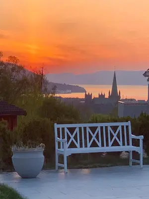 a white bench sitting in front of a sunset at Exclusive villa in Trondheim in Trondheim