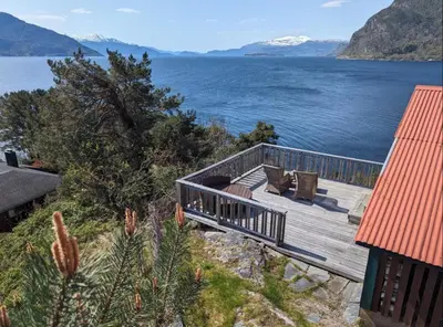 a wooden deck with a view of a body of water at Hardangerfjord panorama 1 in Kvam