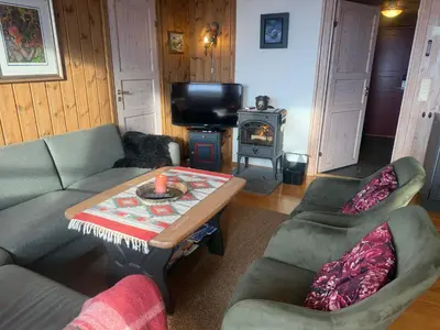 a living room with a couch and a table and a stove at Spacious Apartment For Up To 5 Guests in Beitostøl