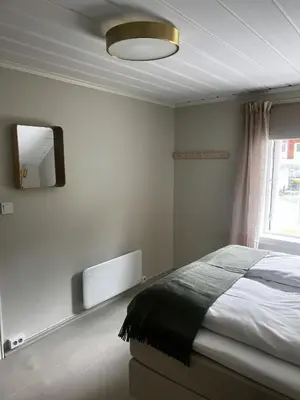 a bedroom with a bed and a mirror on the wall at Grandma`s house in Flåm