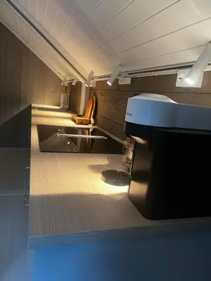 a bathroom with a sink and a chair in a room at Grandma`s house in Flåm