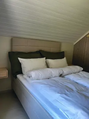 a bed with white pillows on top of it at Grandma`s house in Flåm