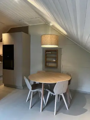 a dining room with a wooden table and chairs at Grandma`s house in Flåm