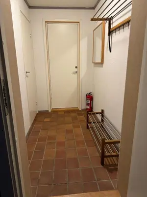 a hallway with a white door and a tiled floor at Nice apartment in quiet neighborhood in Trondheim