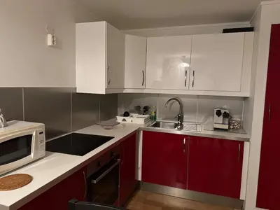 a kitchen with red and white cabinets and a microwave at Nice apartment in quiet neighborhood in Trondheim