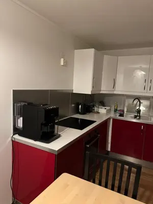 a kitchen with red and white cabinets and a sink at Nice apartment in quiet neighborhood in Trondheim