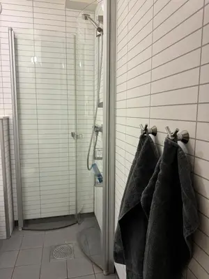a bathroom with three towels hanging on a wall at Nice apartment in quiet neighborhood in Trondheim