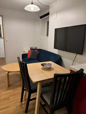 a living room with a table and a blue couch at Nice apartment in quiet neighborhood in Trondheim