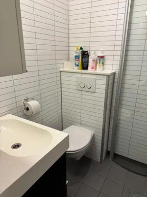 a white bathroom with a toilet and a sink at Nice apartment in quiet neighborhood in Trondheim