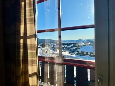 a window with a view of a snow covered town at Leilighet midt i sentrum in Beitostøl