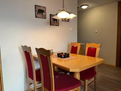 a dining room with a wooden table and chairs at Leilighet midt i sentrum in Beitostøl