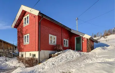 a red house in the snow with snow around it at Gorgeous Home In Svingvoll in Svingvoll