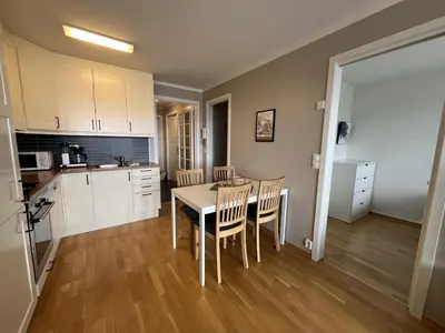 a kitchen and dining room with a table and chairs at Bright, Homey Apartment In Beitostølen Center in Beitostøl