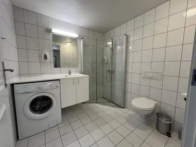 a bathroom with a washing machine and a toilet at Bright, Homey Apartment In Beitostølen Center in Beitostøl