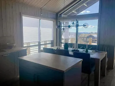 a dining room with a table and chairs and a large window at Enjoy The Calm Setting Of This Cozy Family Cabin in Etnedal