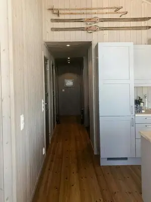 a hallway leading to a kitchen with a hard wood floor at Enjoy The Calm Setting Of This Cozy Family Cabin in Etnedal