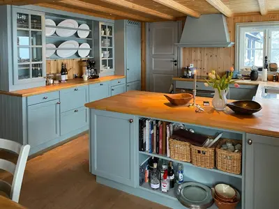 a kitchen with blue cabinets and a wooden counter top at Traditional Cabin In Gålå With Stunning Nature in Gålå