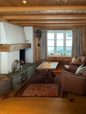 a living room with a fireplace and a couch and a table at Traditional Cabin In Gålå With Stunning Nature in Gålå
