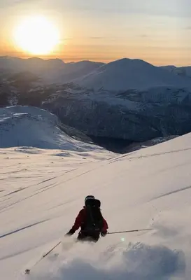 a person on skis in the snow at sunset at Panoramic Cabin With Fjord Views In Valldal in Valldal