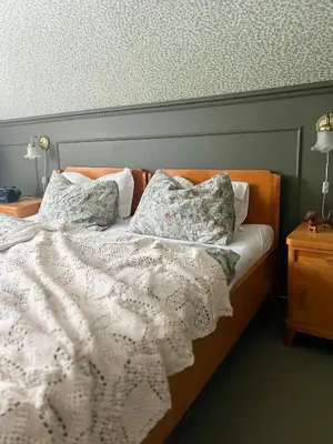 a bed with a white comforter and pillows on it at Historic Villa By The Sea In Solund in Hardbakke