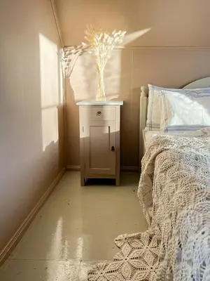 a bedroom with a bed and a vase on a night stand at Historic Villa By The Sea In Solund in Hardbakke