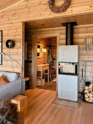 a living room with a refrigerator and a table at Cozy Modern Mountain Cabin At Kvamsfjellet in Kvam