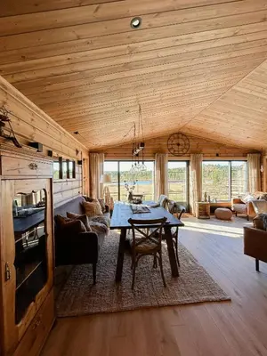 a living room with a wooden ceiling and a table at Cozy Modern Mountain Cabin At Kvamsfjellet in Kvam