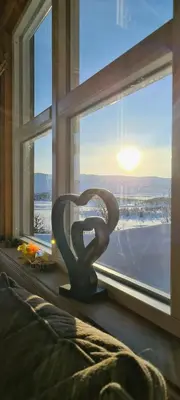 a sculpture in a window with a view of the snow at Cozy Cabin With A Beautiful View in Øygardsgrend