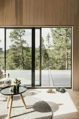 a living room with a table and a large window at Cabin By Selbusjøen With Ski And Trail Access in Selbu