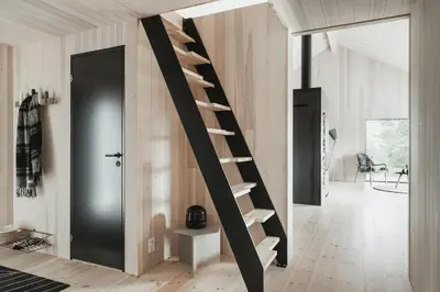 a spiral staircase in a room with a black door at Cabin By Selbusjøen With Ski And Trail Access in Selbu