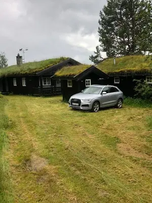 a car parked in front of a house with a grass roof at Mountain Cabin With Views And Close To Ski Trails in Aurdal