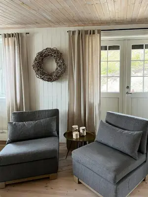 a living room with two chairs and a table at Designer Cabin With Panoramic Views In Hovden in Bykle