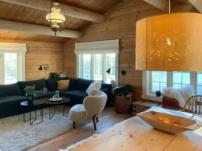 a living room with a couch and a table at Idyllic Log Cabin At Nordseter in Lillehammer