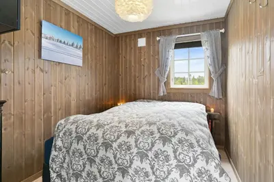 a bedroom with a bed and a window at Peaceful Cabin With View And Jacuzzi At Blefjell in Kongsberg