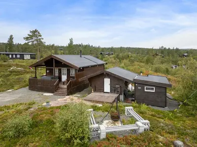 a log cabin in the middle of a field at Peaceful Cabin With View And Jacuzzi At Blefjell in Kongsberg