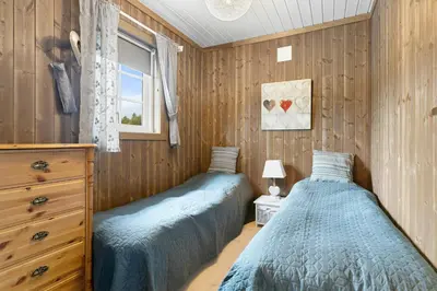 two beds in a bedroom with wooden walls at Peaceful Cabin With View And Jacuzzi At Blefjell in Kongsberg