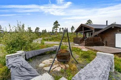 a garden in front of a log cabin at Peaceful Cabin With View And Jacuzzi At Blefjell in Kongsberg