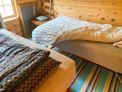 a bedroom with two beds and a window at Mountain Cabin By Hundsåvatnet With Large Veranda in Søvassli