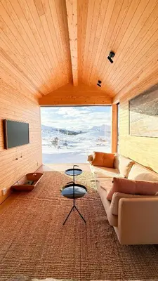 a living room with a couch and a table at Architect-Designed Cabin By Rondane in Høvringen