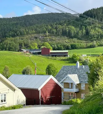 a red barn and a house in a village at Charming & Modern Seaside House In Valsøyfjord in Valsøyfjord