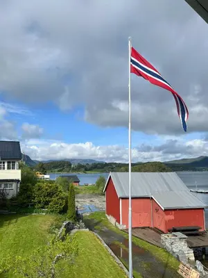 an american flag flying in front of a red barn at Charming & Modern Seaside House In Valsøyfjord in Valsøyfjord